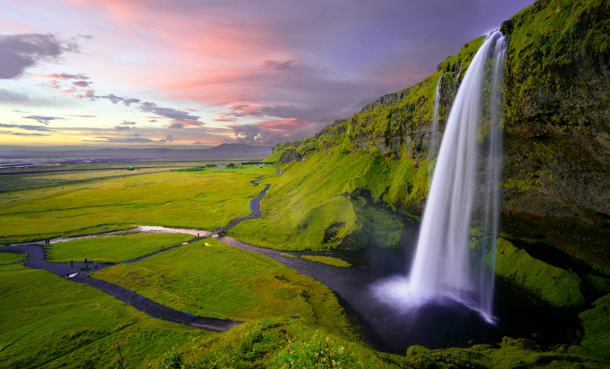 Waterfall cascading over a green cliff in Iceland